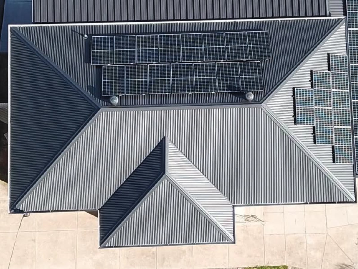 The same home from above with a new dark metal roof and a much larger solar array